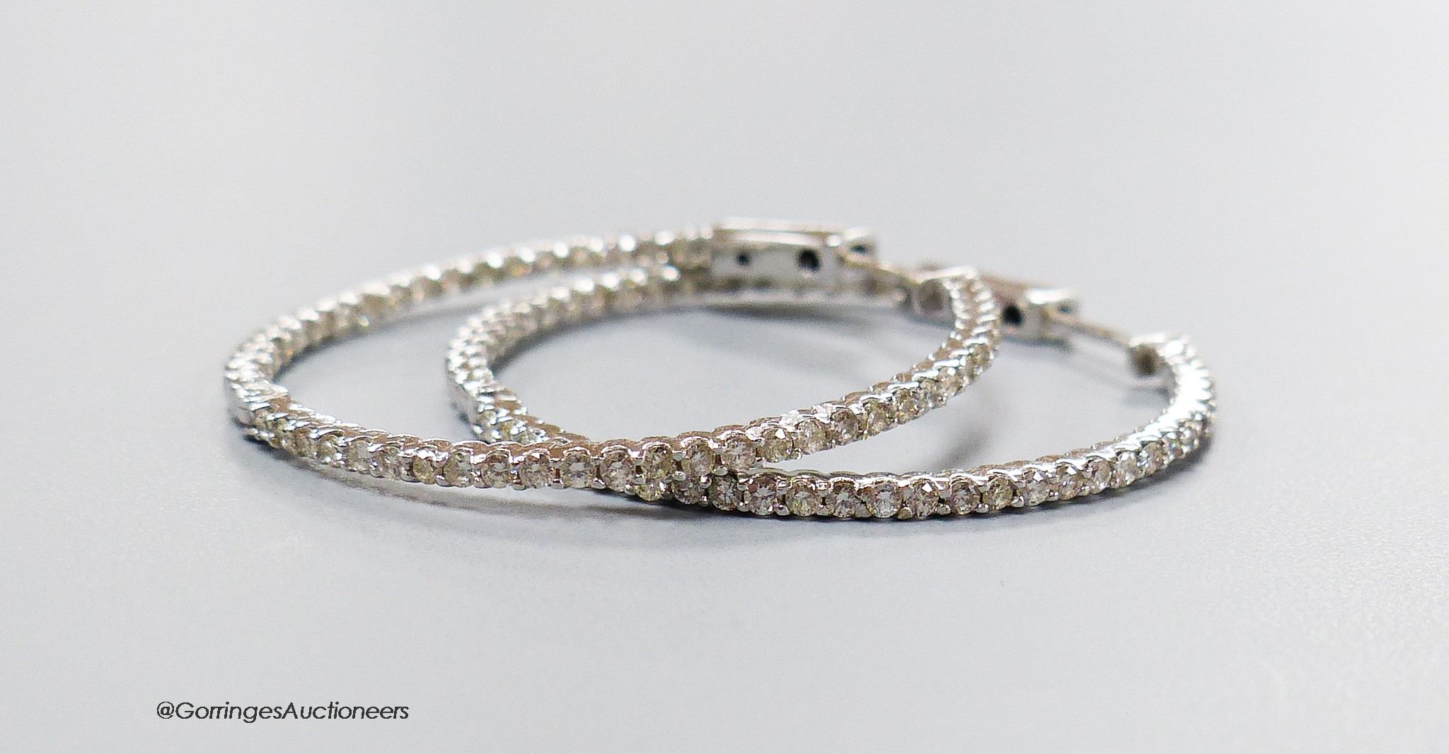 A modern pair of 18ct white gold and diamond chip set hoop earrings, diameter 32mm, gross weight 5.4 grams.